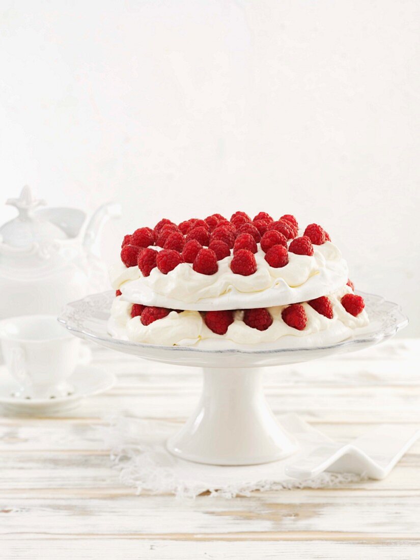 Pavlova Topped with Whipped Cream, Raspberries and Powdered Sugar