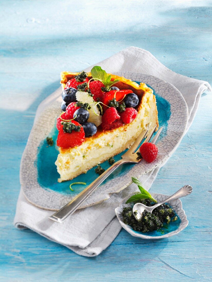 A slice of lime cheesecake with berries and mint pesto