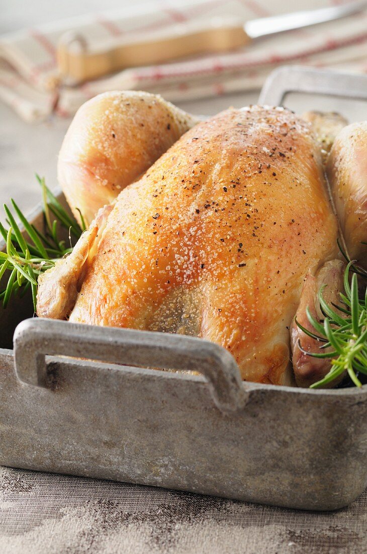 Roast chicken with rosemary in a roasting tin