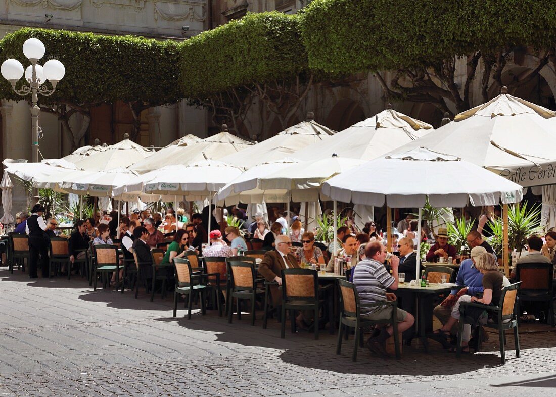 Street café with sun shades and lots of guests