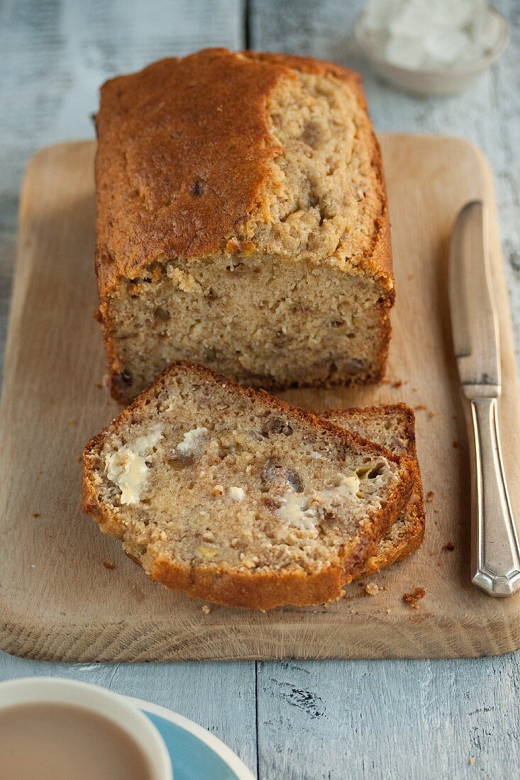 Banana bread with butter on a chopping board