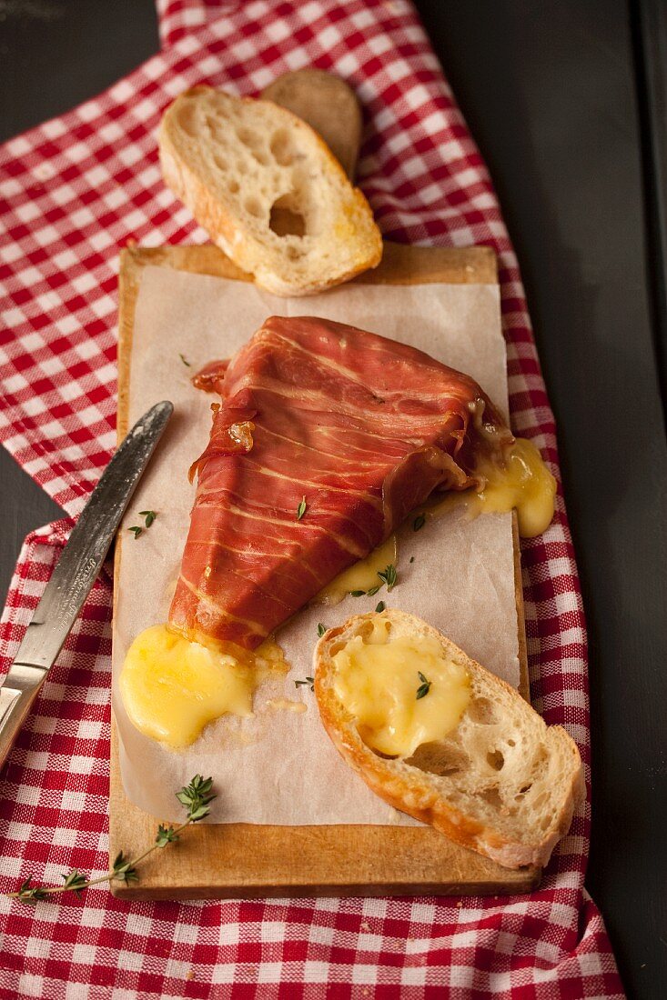 Baked Brie wrapped in Prosciutto, with slices of baguette