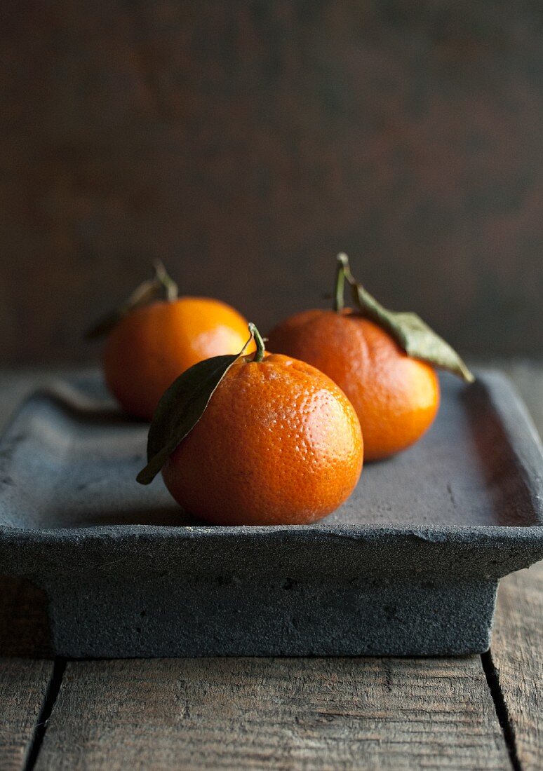 Three clementines with leaves