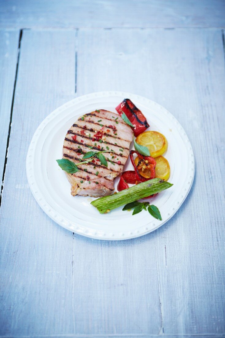 Grilled smoked pork chop with peppers and lemon
