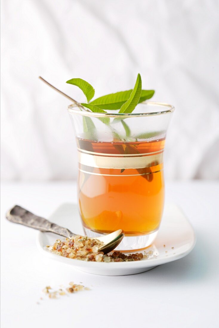 Tea in a glass with a sprig of herbs