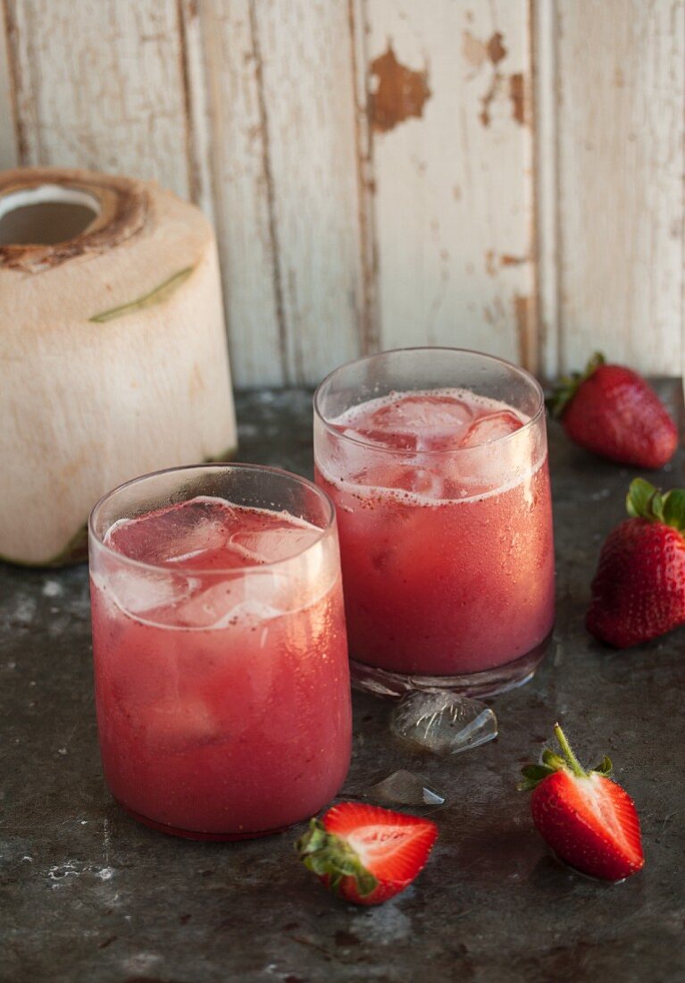 Strawberry and coconut water drinks with ice cubes
