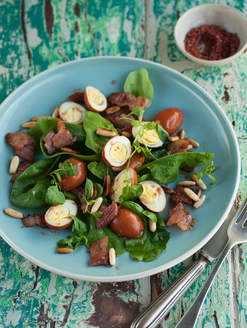 Spinatsalat mit in Tee pochierten Wachteleiern und Bacon