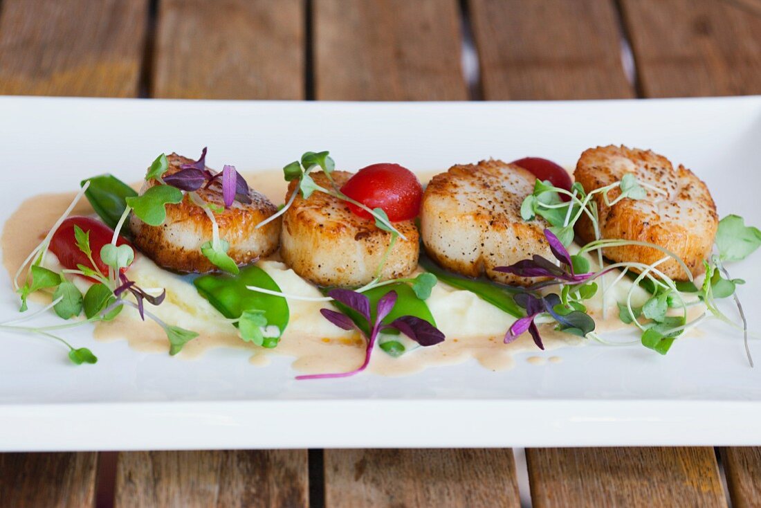 Seared Scallops in White Dish on Restaurant Table