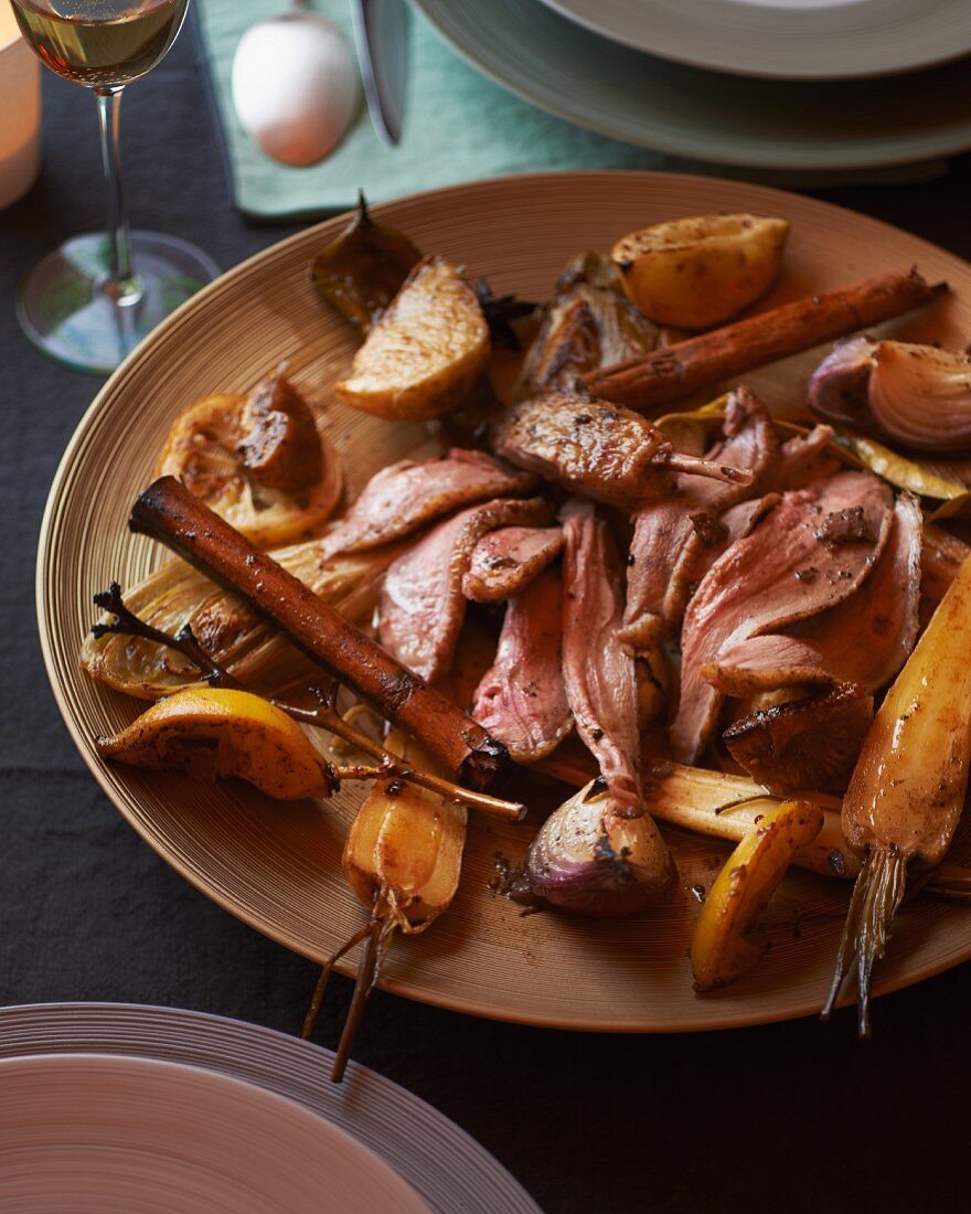 Sliced roast duck with spices, onions and carrots