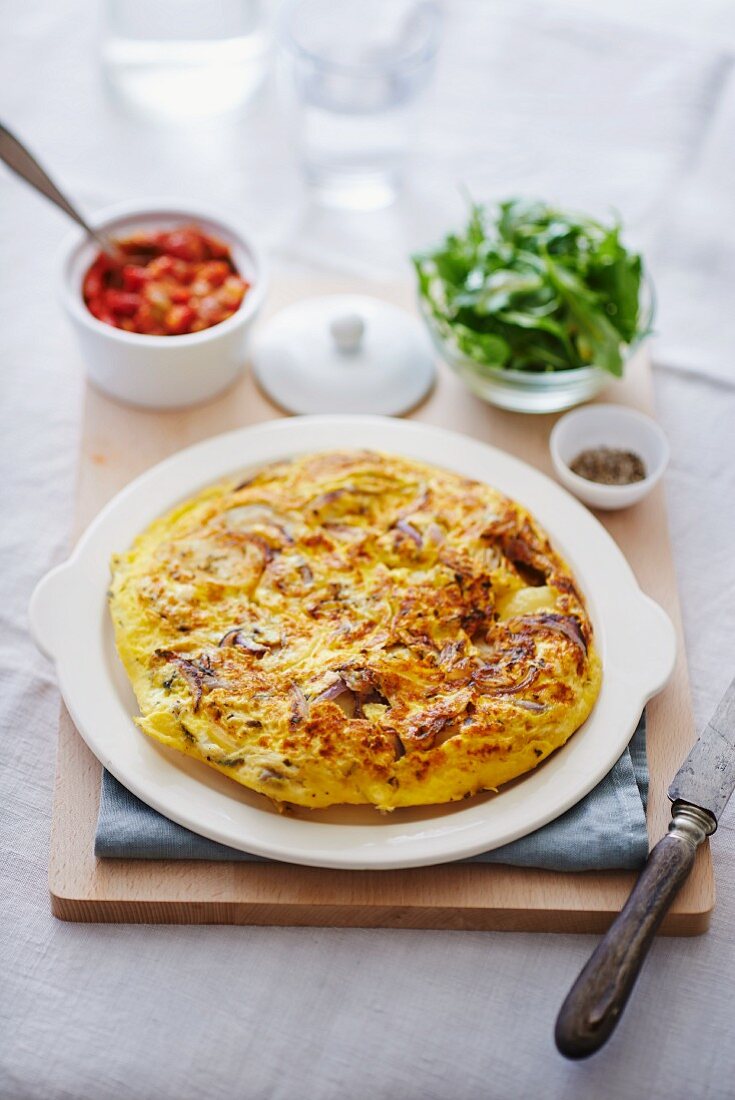 Omelette with onions, rocket and tomato sauce