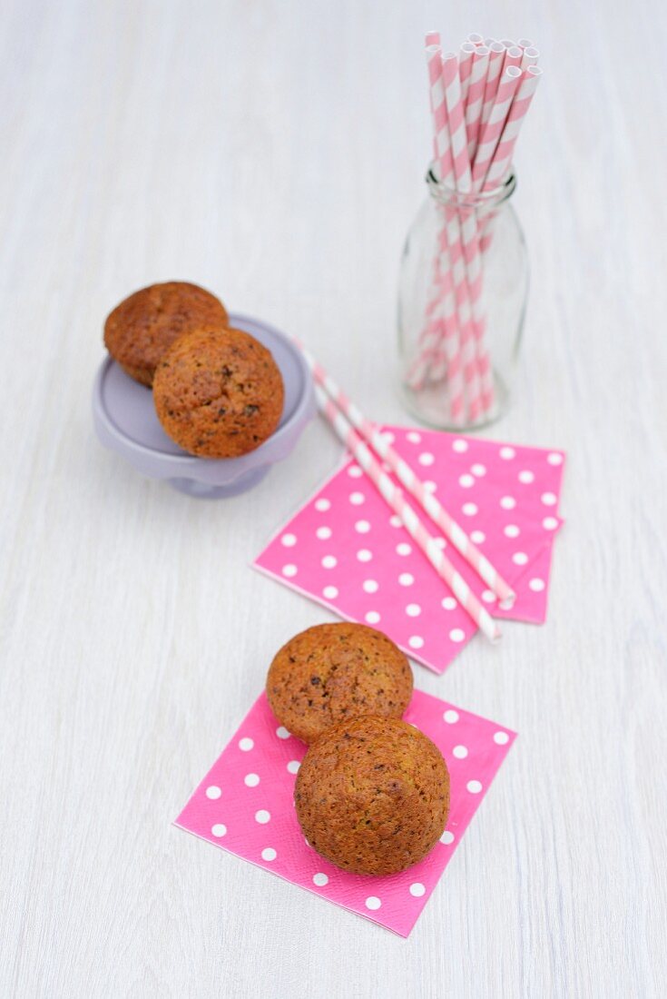 Banana muffins with chocolate, paper napkins and drinking straws
