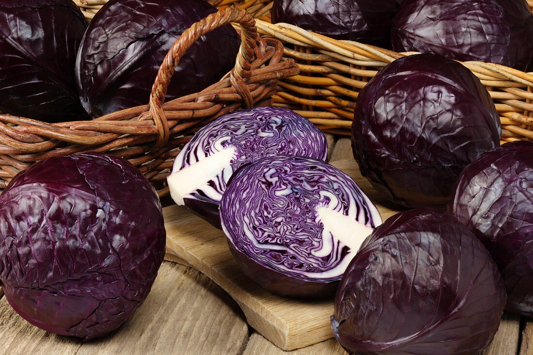 Red cabbage in baskets and on a chopping board, whole and cut in half