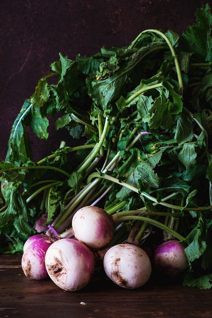 Several white turnips on a wooden table