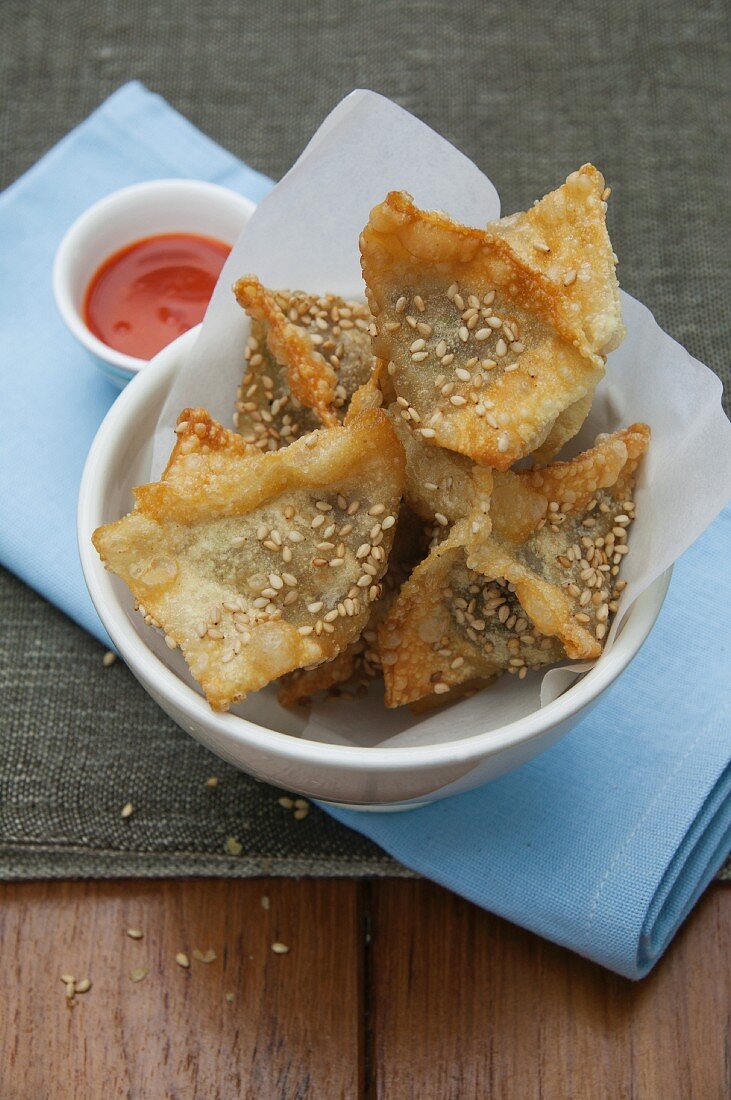 Frittierte Teigtäschchen mit Sesam und Chilisauce (Asien)