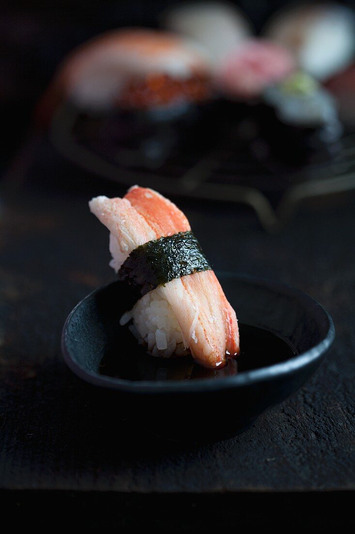 Sushi mit Krebsfleisch wird in Sojasauce getaucht