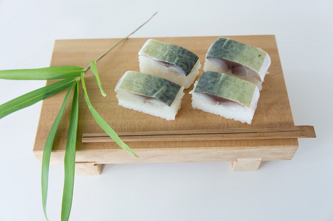 Oshi-Sushi mit Makrele auf Holzbänkchen