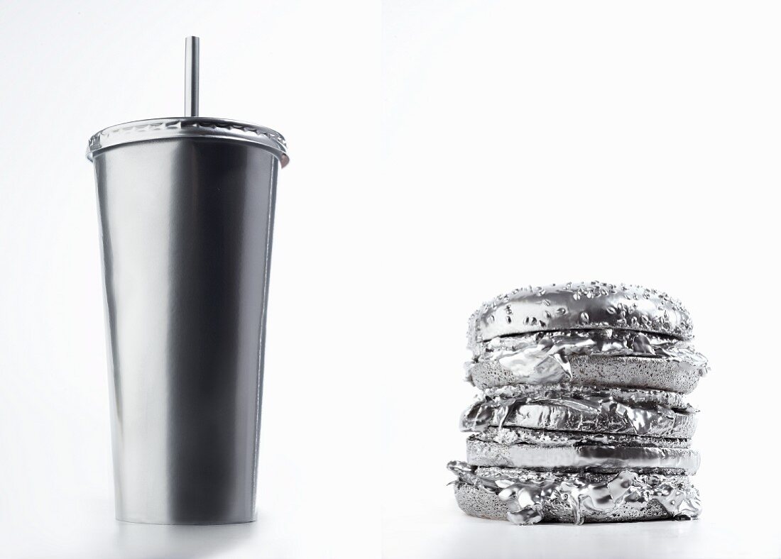 A cardboard drinks container and a hamburger (silver-coloured)