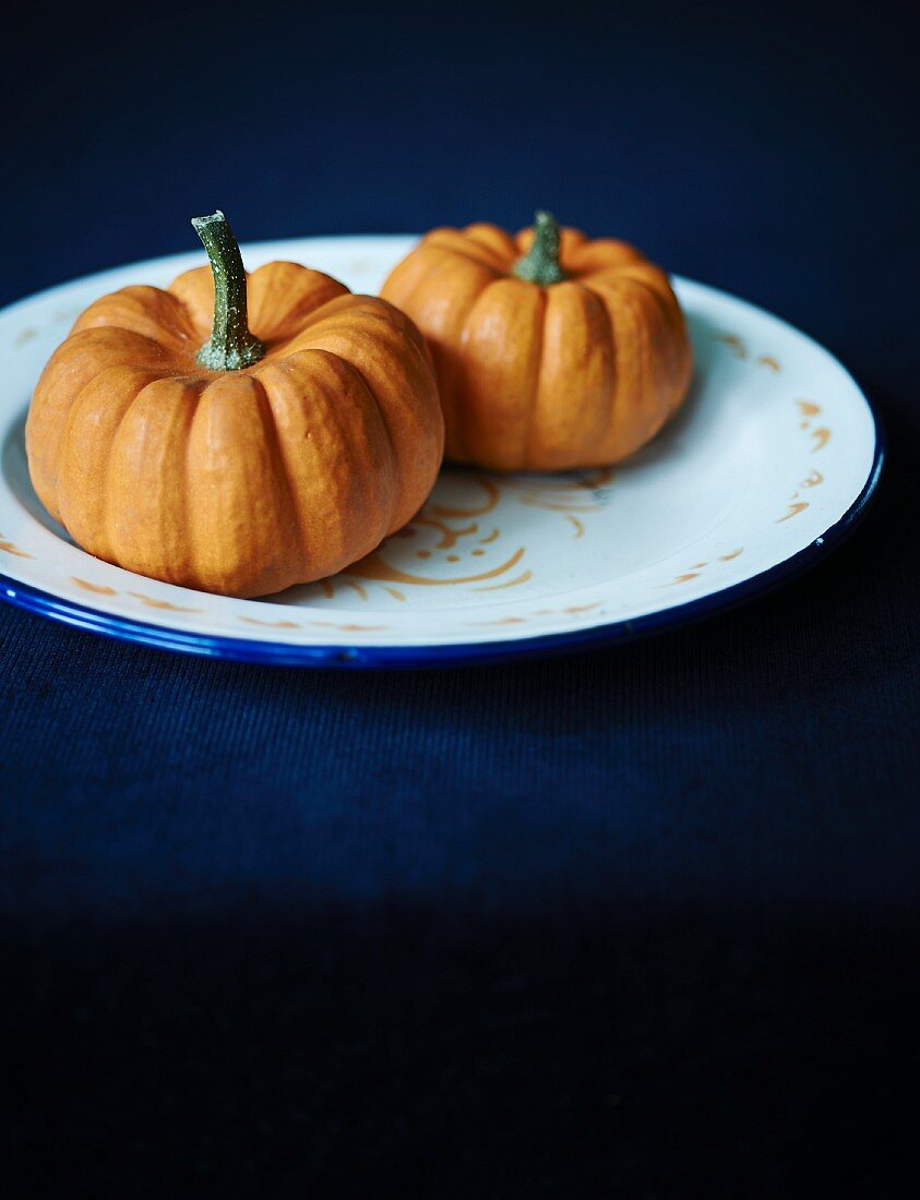 Two orange squashes on a plate