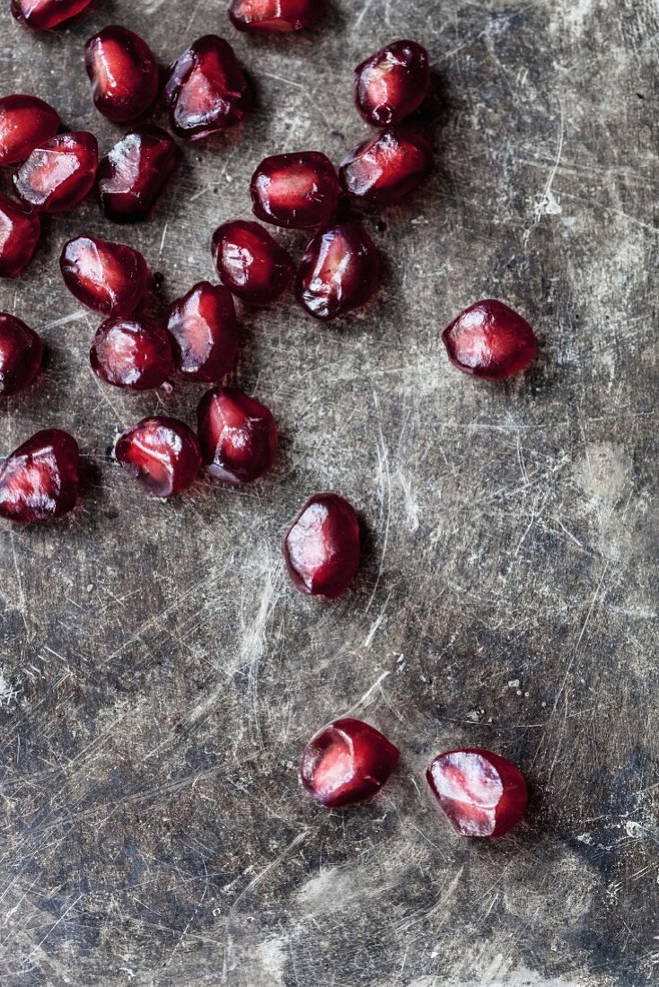 Pomegranate seeds on a stone surface