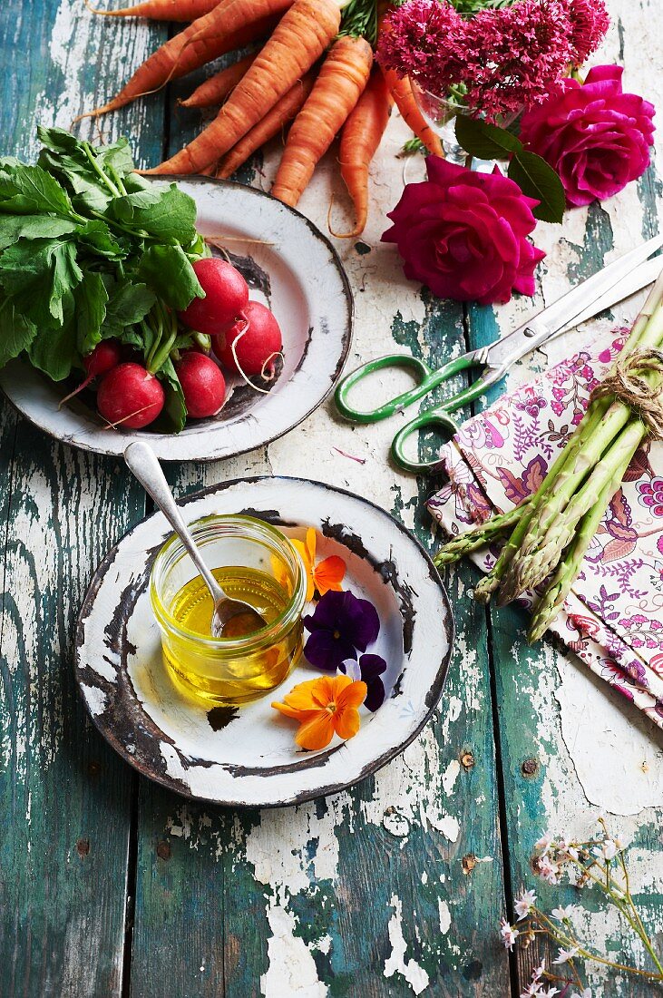 Honig, Gemüse und Blumen auf verwittertem Gartentisch