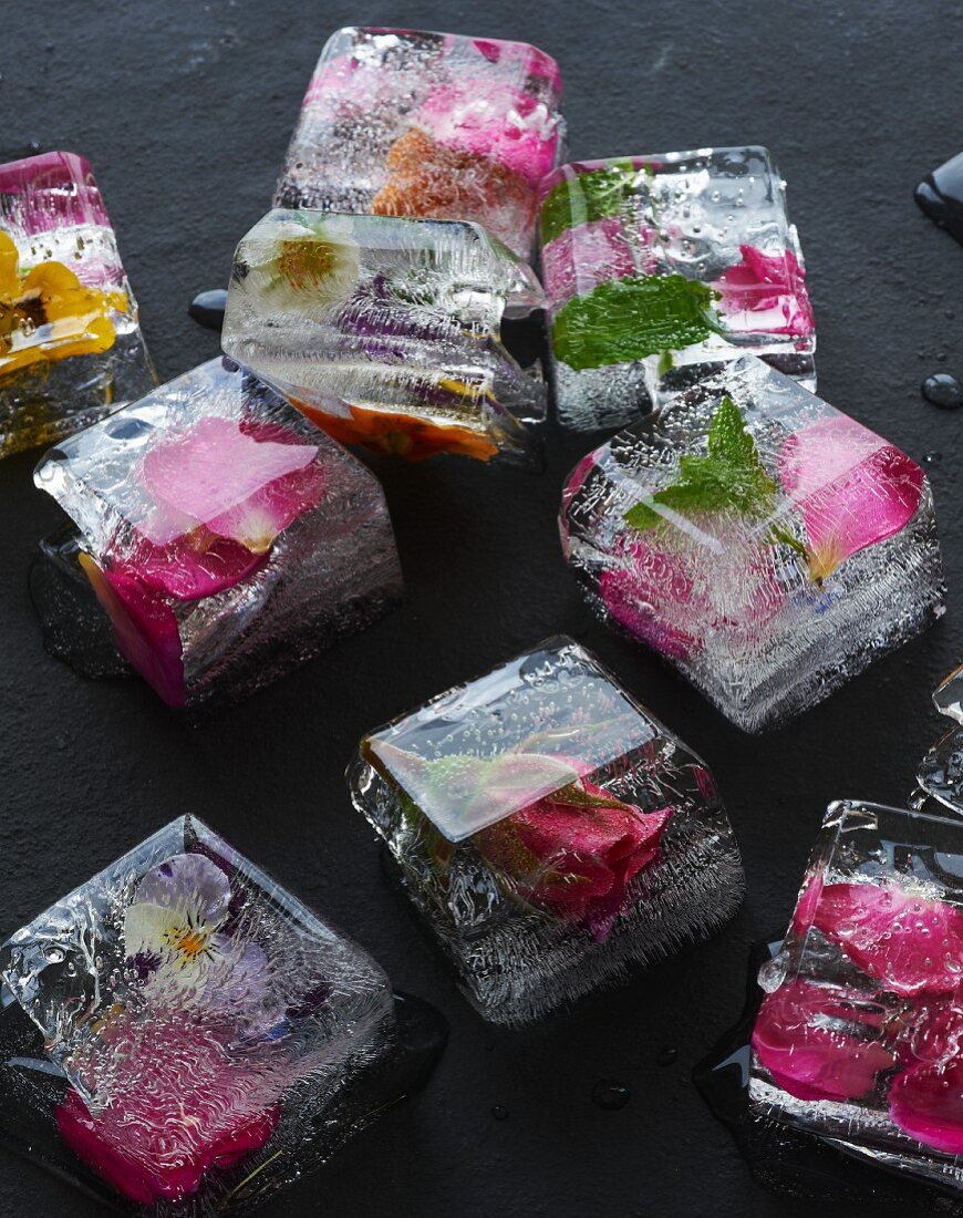 Several ice cubes containing edible flowers
