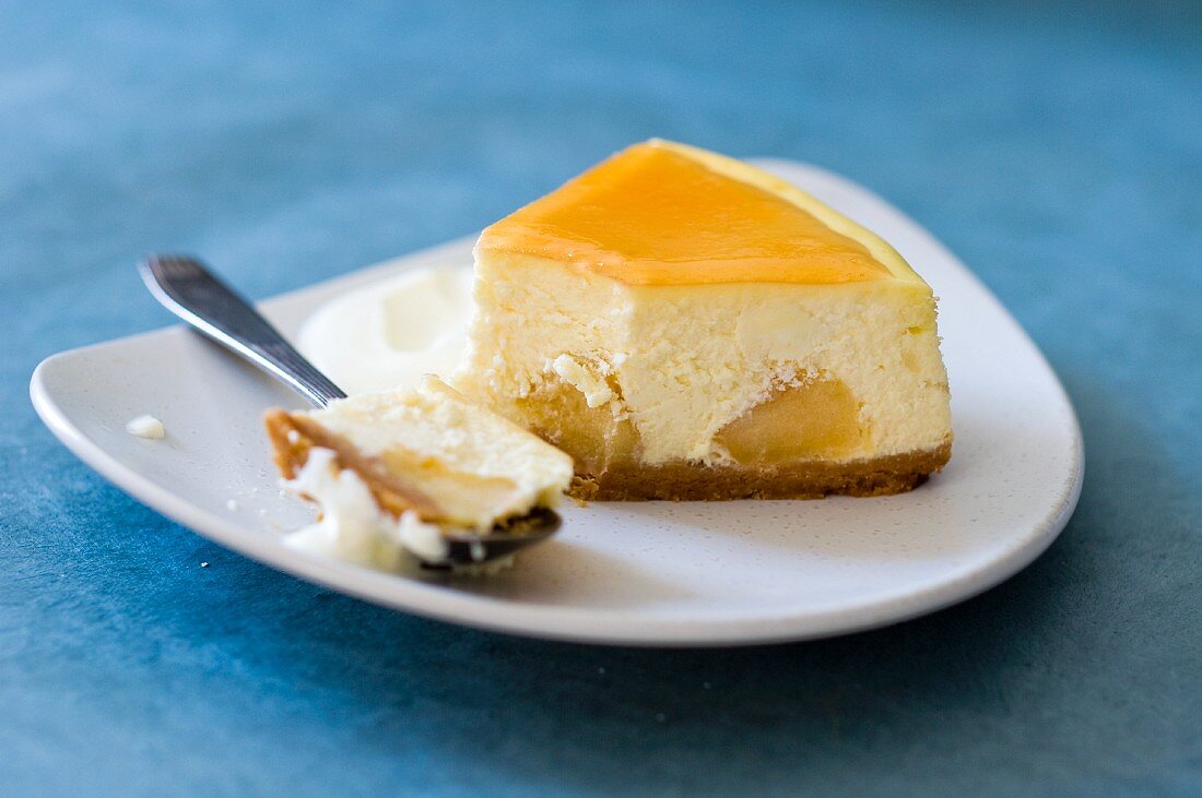 Ein Stück Käsekuchen mit Apfel