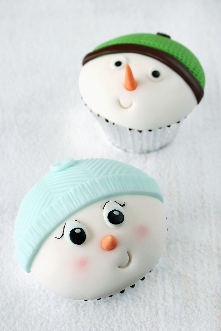 Zwei lustige Cupcakes mit Schneemanngesichtern
