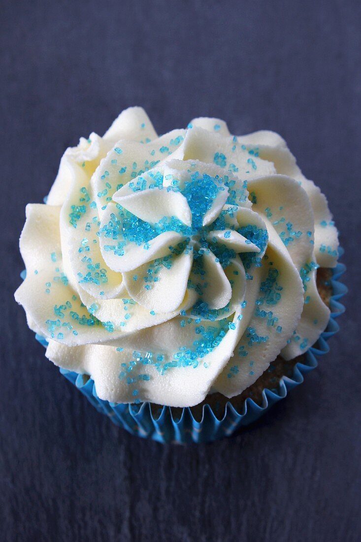 A cupcake with buttercream icing and blue sugar