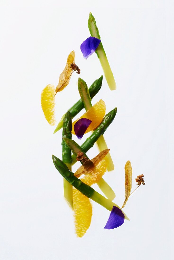 Green asparagus with orange segments and lime flowers