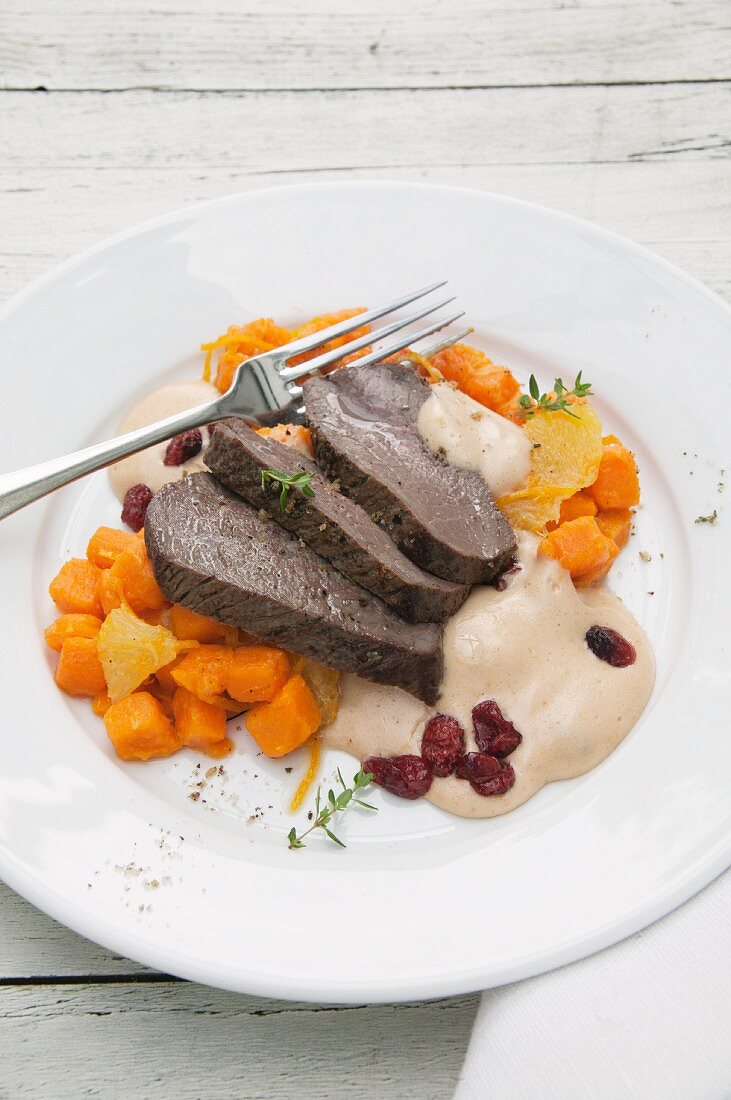 Roasted leg of venison with cranberry hollandaise and sweet potatoes cooked with orange
