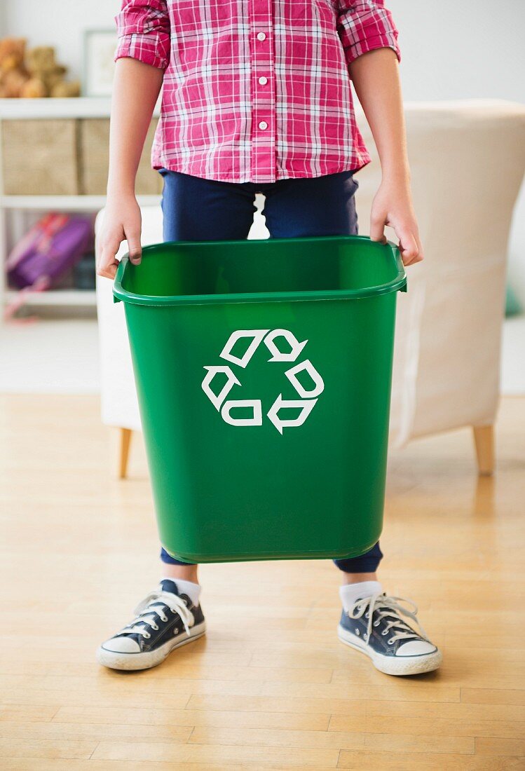 Boy carrying bin with recycling symbol