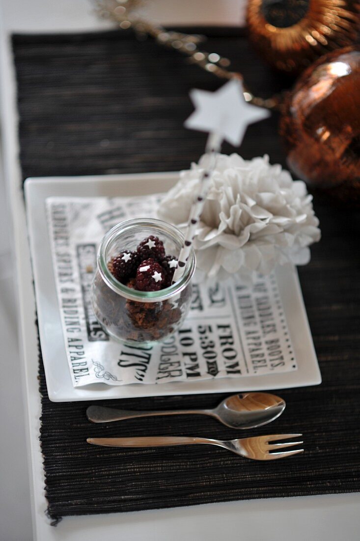 A Christmassy place setting with floral decoration and Christmas tree baubles