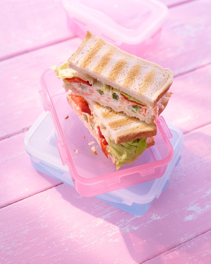 Cream cheese sandwiches in a Tupperware container