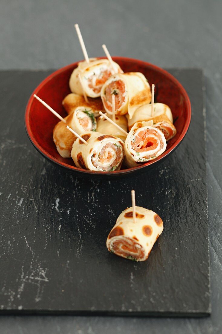 Rolled strips of pancake filled with smoked salmon, cheese and dill