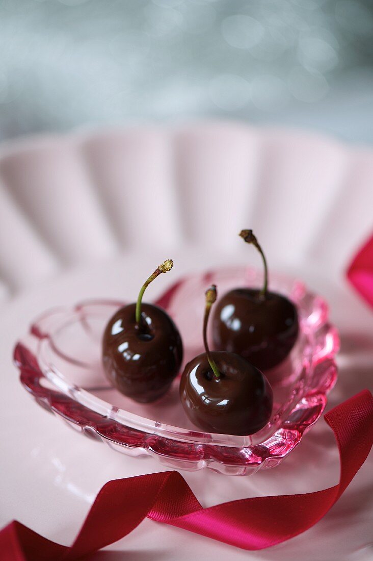 Chocolate-coated cherries on a heart-shaped dish for Valentine's Day