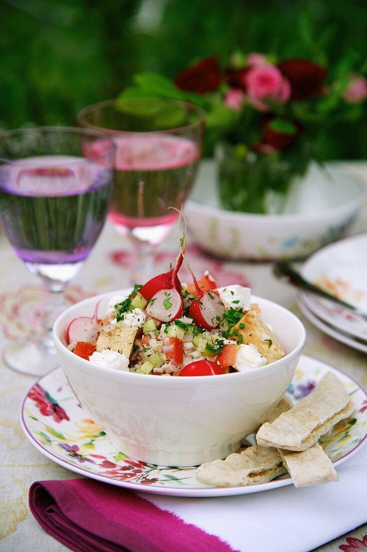A mixed salad with radishes and feta cheese