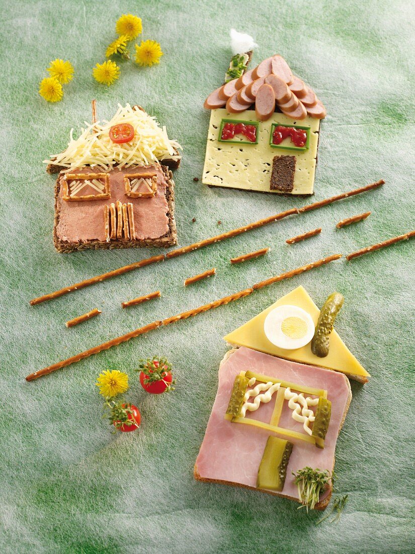 Wholemeal bread houses with ham, cheese and pickled gherkins