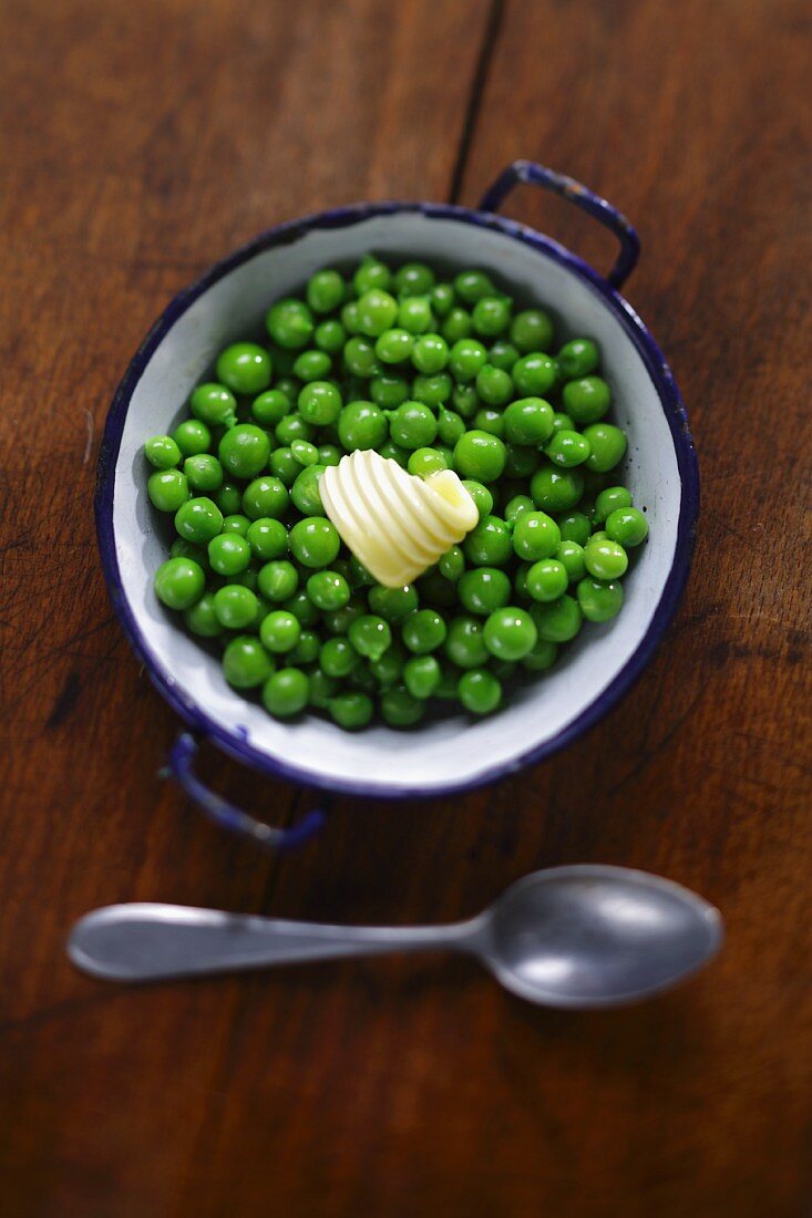 Cooked peas with a curl of butter (view from above)