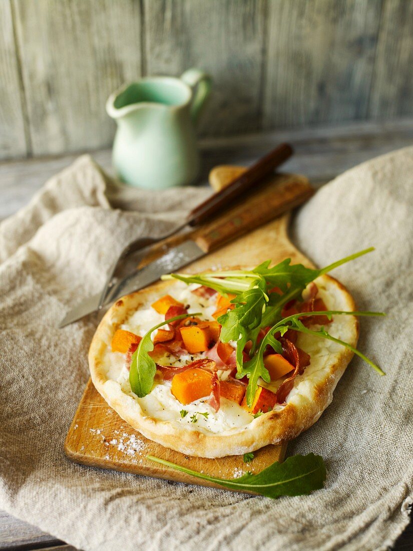 Mini pizza with squash, bacon and rocket