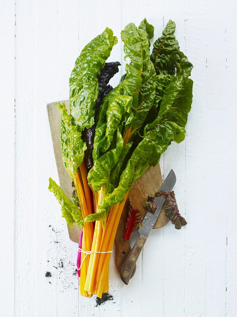 Fresh chard, tied in a bunch, on a chopping board