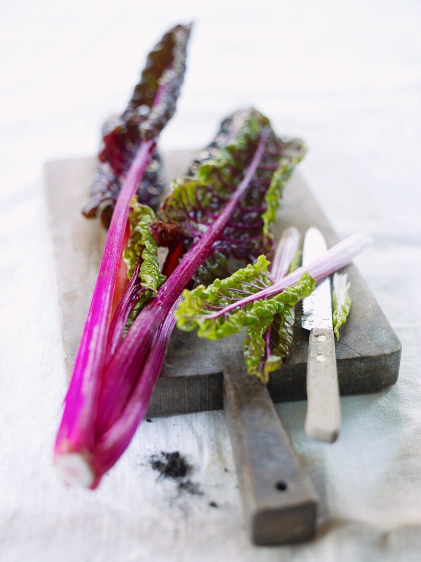 Red chard with a knife on a chopping board
