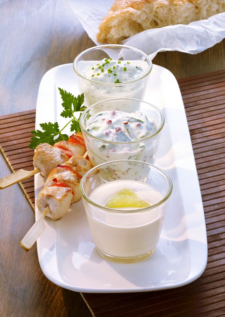 Lime dip, cucumber dip and cream cheese & herb dip served with chicken skewers