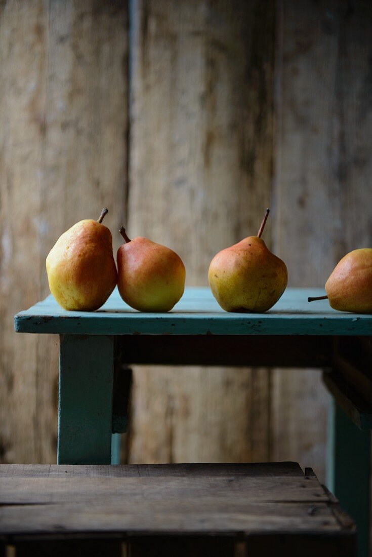 Four pears on a wooden table