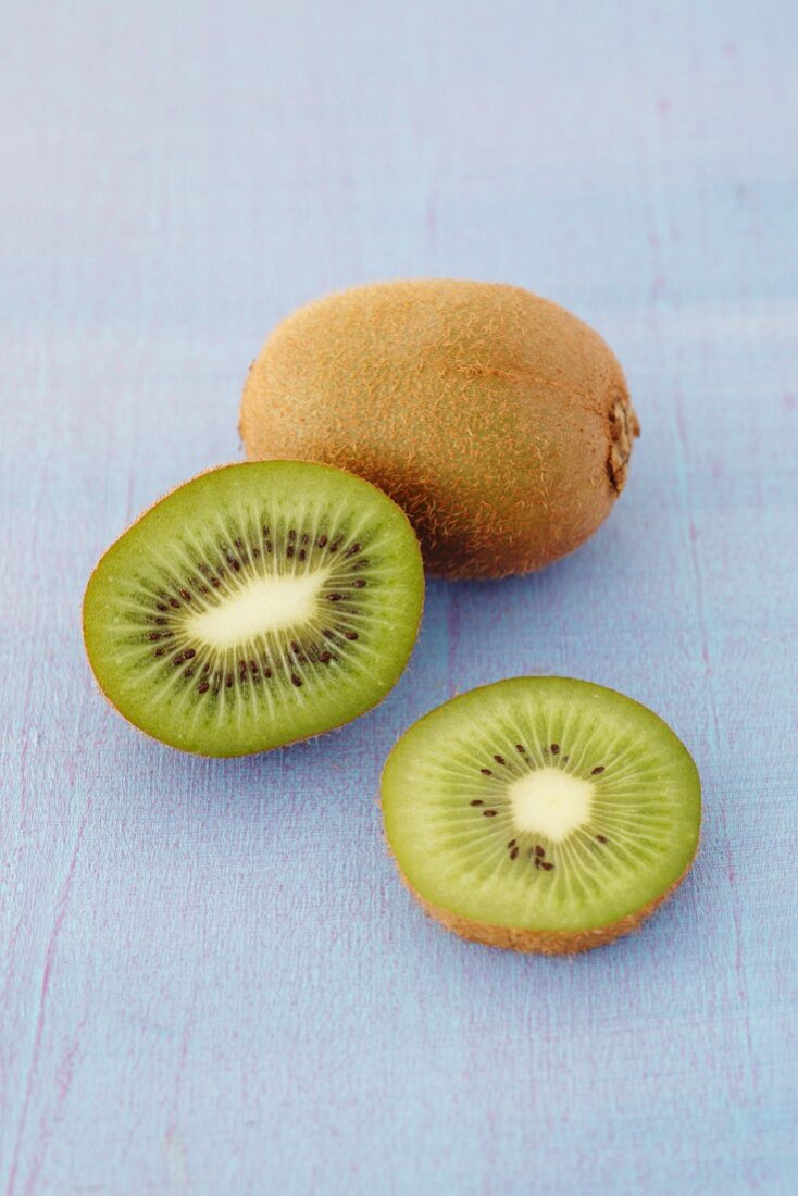 A whole kiwi and sliced kiwis