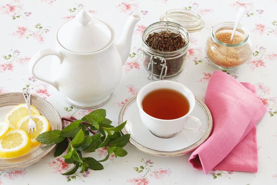 Peppermint tea, tea leaves, sugar and lemon slices