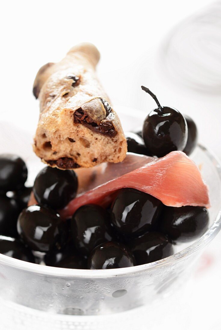 Olivenbaguette, schwarze Oliven und Rohschinken