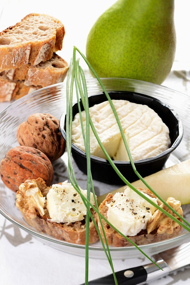 Slices of bread topped with goat's cheese, pears and nuts