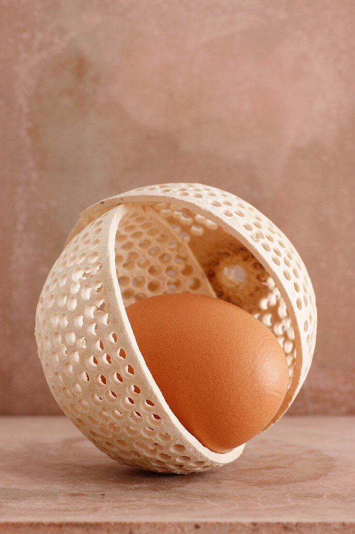 A brown egg in an ornate bowl