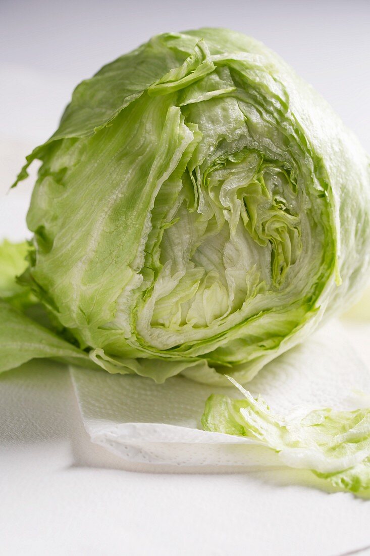 A partly sliced fresh iceberg lettuce