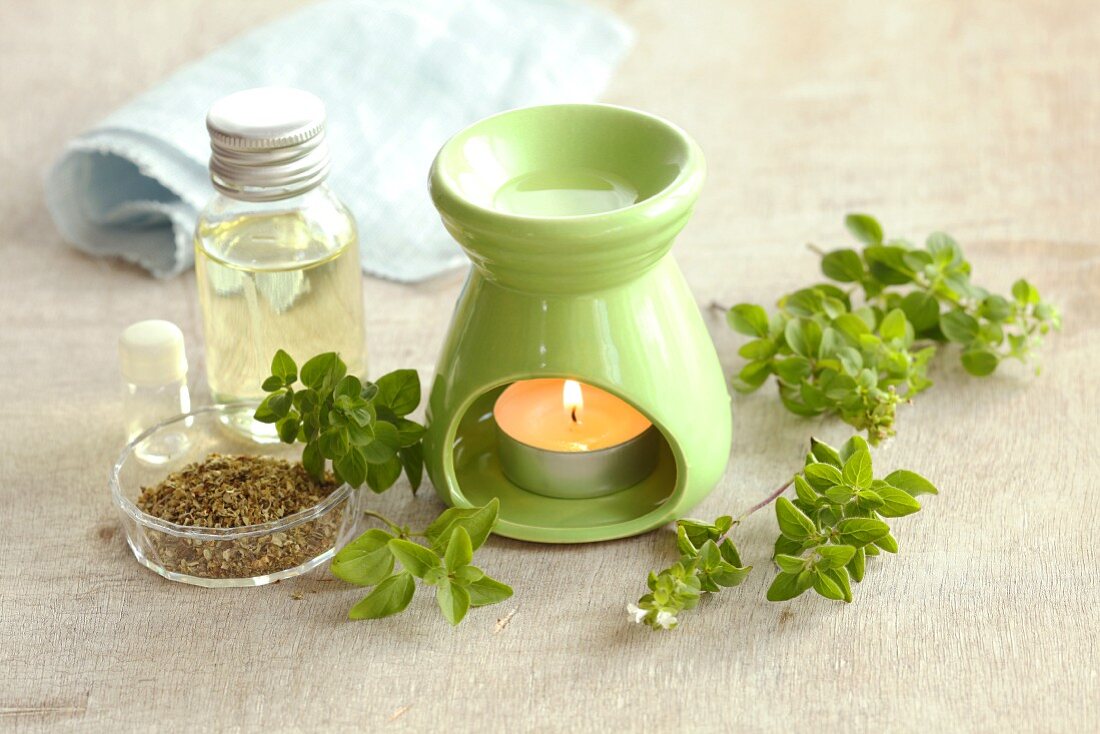 Marjoram oil and marjoram (fresh and dried) with a scented oil lamp